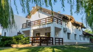 a large white house with a thatched roof at Califarul Alb in Chilia Veche