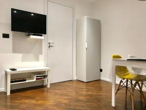 ein Wohnzimmer mit einem Schreibtisch und einem TV an der Wand in der Unterkunft Otello Apartment in Genua