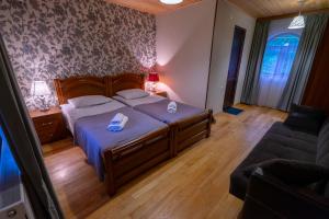 una camera da letto con un letto grande e un divano di Guesthouse David Zhorzholiani a Mestia