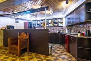 una cucina con un bar con una sedia al suo interno di Guesthouse David Zhorzholiani a Mestia