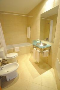 uma casa de banho com um lavatório, um WC e um espelho. em Oceano Atlantico Apartamentos Turisticos em Portimão