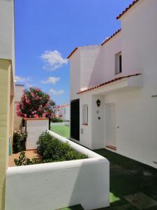 una casa bianca con cortile con un fioraio di VILLA DIPLOMADO (RELAX EN EL PARAISO) a Es Mercadal