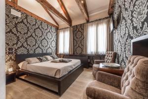 Un dormitorio con una cama, un sofá y una silla. en Abbazia De Luxe, en Venecia