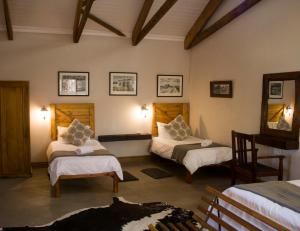 A bed or beds in a room at Aan die Oewer Guesthouse