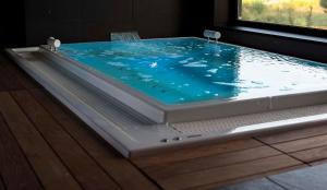 een bad gevuld met blauw water in een kamer bij Moana Eco Surf House in Sopelana