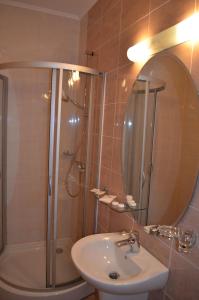 a bathroom with a shower and a sink and a mirror at Pensiunea Magura in Baia Mare