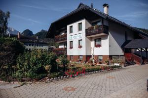 ein Gebäude mit Blumen und Pflanzen davor in der Unterkunft B&B Brezov Gaj in Kranjska Gora