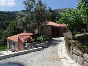 a house with a red door on a road at Casa do Silvério in Santa Cruz do Douro