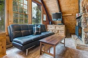 a living room with a leather couch and a table at Creekside Chalet in Alta