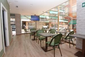 um restaurante com mesas e cadeiras em frente a um edifício em Hotel Castillo Benidorm em Benidorm