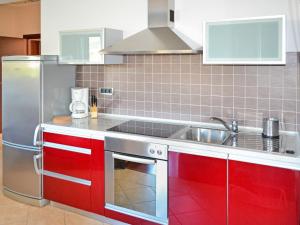 a kitchen with red cabinets and a stainless steel refrigerator at Apartment Jadranka-3 by Interhome in Rab