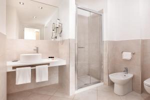 a bathroom with a toilet, sink, and shower at Hotel Sina Astor in Viareggio