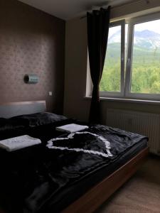 ein Schlafzimmer mit einem Bett vor einem Fenster in der Unterkunft Apartmán pod Gerlachovským štítom in Vysoké Tatry