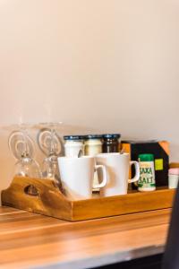 ein Holzregal mit Tassen und anderen Gegenständen darauf in der Unterkunft Rolleston Paradise-Master Bedroom with Ensuite Only in Rolleston