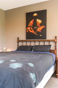 罗尔斯顿Rolleston Paradise-Master Bedroom with Ensuite Only的卧室里有一张床，墙上挂着一幅画