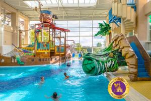 a group of people in a swimming pool at a water park at Explorers Hotel Marne-la-Vallée in Magny-le-Hongre