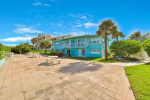 niebieski budynek ze stołami piknikowymi przed nim w obiekcie The Simple Life w mieście Cocoa Beach
