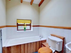 カーナーヴォンにあるHoliday Home Llanfaglan House by Interhomeのバスルーム(バスタブ、トイレ付)、窓が備わります。