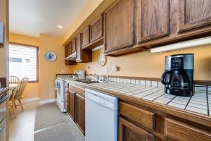 a kitchen with wooden cabinets and a coffee maker on the counter at Whale-come Home in Depoe Bay