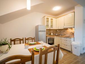 a kitchen with a table and a refrigerator at Apartment Oltari-3 by Interhome in Biljevine