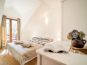 a bedroom with two beds and a book on a table at Apartment Oltari-3 by Interhome in Biljevine