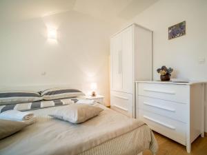 a white bedroom with two beds and a dresser at Apartment Oltari-3 by Interhome in Biljevine