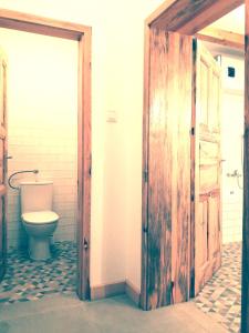 een badkamer met een toilet en een houten deur bij Füveskert in Erdőbénye