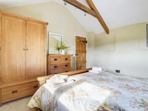 a bedroom with a large bed and a wooden cabinet at Holiday Home Crow by Interhome in Witheridge