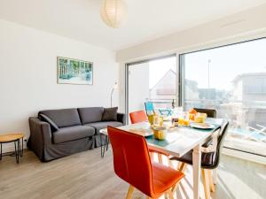 Port-HaliguenにあるApartment Les Gemeaux-3 by Interhomeのテーブルと椅子とソファのあるリビングルーム