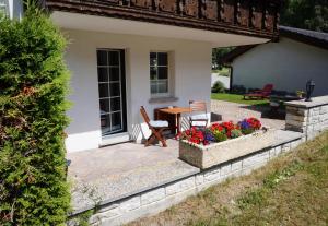 a patio with flowers in a planter in front of a house at Art Oase - Lenzspitze in Saas-Grund