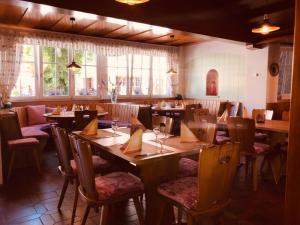 un restaurante con mesas y sillas de madera y ventanas en Gasthof Hirschen en Gailingen