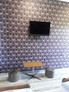 uma sala de estar com uma parede coberta por um papel de parede de inspiração marroquina em Hotel E U R O P E em Kvareli