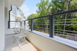 a balcony with a table and chairs on it at Apartamenty Świnoujście - Wyspiańskiego 34e in Świnoujście