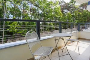 a balcony with two chairs and a table at Apartamenty Świnoujście - Wyspiańskiego 34e in Świnoujście