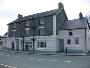 a large white building on the side of a street at Holiday Home Ty Pennal by Interhome in Pennal