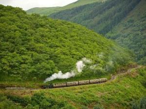 LlanilarにあるHoliday Home Dinas y Gadair by Interhomeの煙が来る山を下る列車
