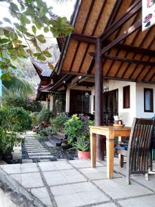 a patio with a wooden table and chairs in front of a building at Villa coral Cafe in Amed