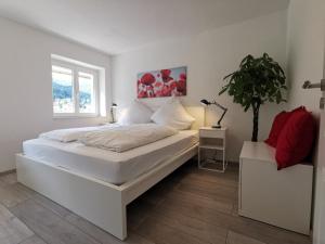Un dormitorio blanco con una cama grande y una planta en Ferienwohnungen Flussufer - Neckargemünd Altstadt, en Neckargemünd