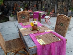 a wooden table with a purple table cloth on it at Chez nous in Pereybere