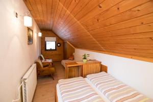um pequeno quarto com uma cama e um tecto de madeira em Sobe Odar Andrej em Bohinj