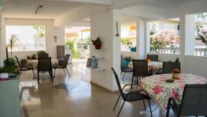 a dining room with tables and chairs and windows at Niki Apartments in Paralia Dionysiou