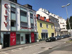 a street with cars parked in front of buildings at City Hotel Albrecht in Schwechat