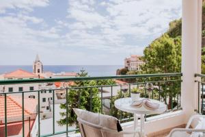 a balcony with a table and chairs and a view of the city at Vila Mar Apartment in Ponta do Sol