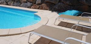 a swimming pool with two lounge chairs next to it at La villa marquesa in Fitou