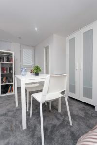 a white dining room with a white table and chairs at Leeds House in Leeds