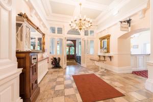 an ornate hallway with a chandelier and a large room at Grange Hotel in Grange Over Sands