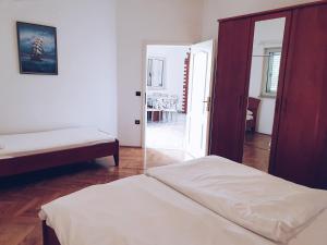 a bedroom with two beds and an open door at Villa Dubravka in Lopar