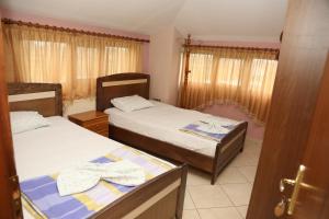 um pequeno quarto com 2 camas e uma janela em Hotel Villa Kabashi em Korçë