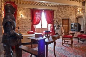 a room with a room with a bed and a statue of a knight at Château de Chantelauze in Olliergues +25 photos