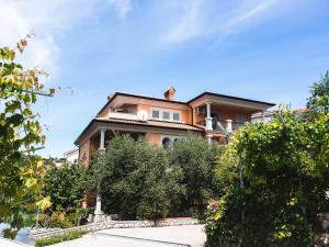 a house on a hill with bushes in front of it at Villa Dubravka in Lopar